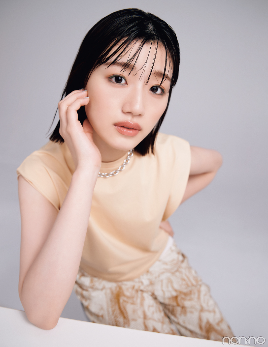 シンプルな洋服とグリーンの目元メイクの佐々木美玲