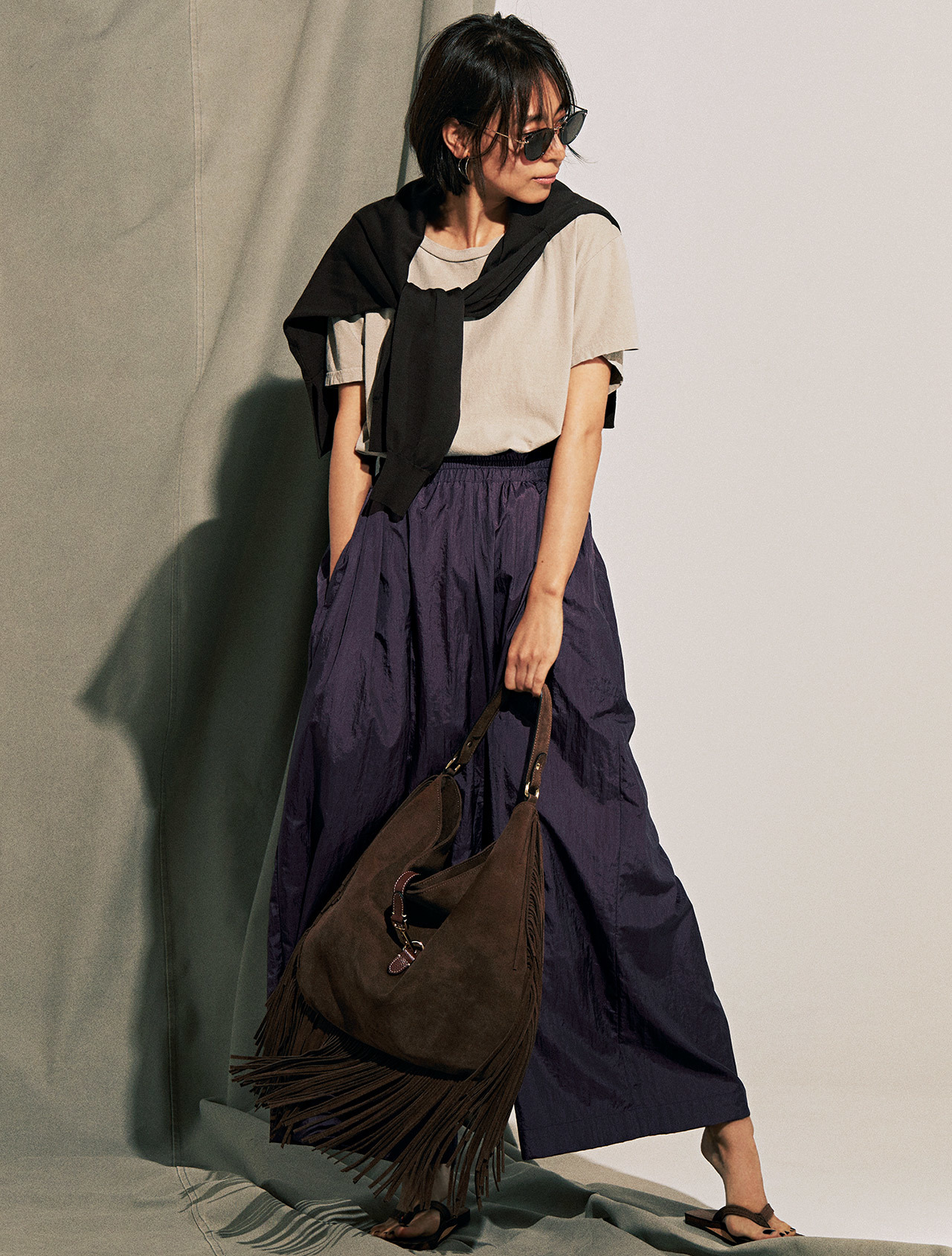 肩がけニット×Tシャツ×パープルのツヤパンツコーデを着たモデルの小泉里子さん