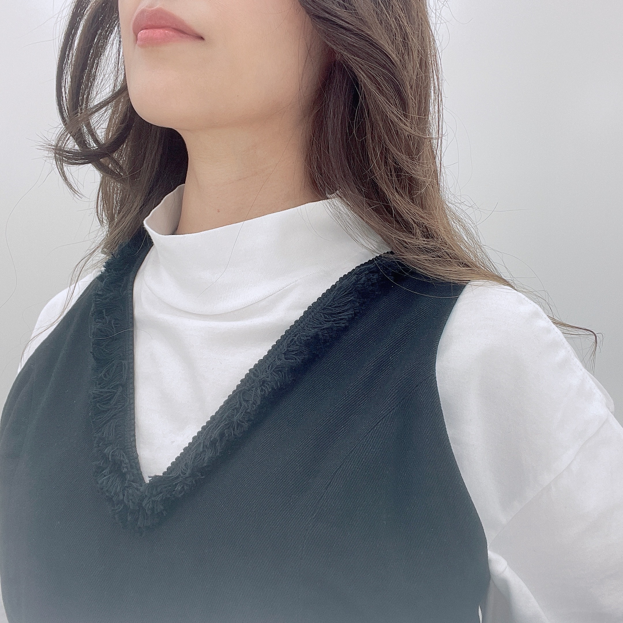 インナーは白のハイネックTシャツ