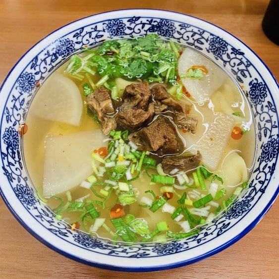 澄んだスープ、麺の白、野菜の緑、牛肉の茶色、辣油の赤と、目にも鮮やかな蘭州牛肉麺。