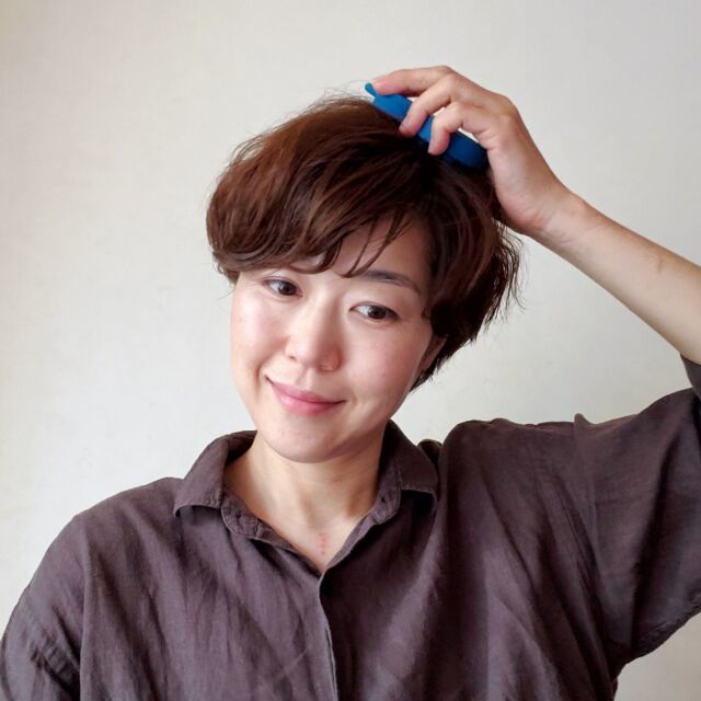 やみつき 頭皮マッサージブラシをするウマキさん