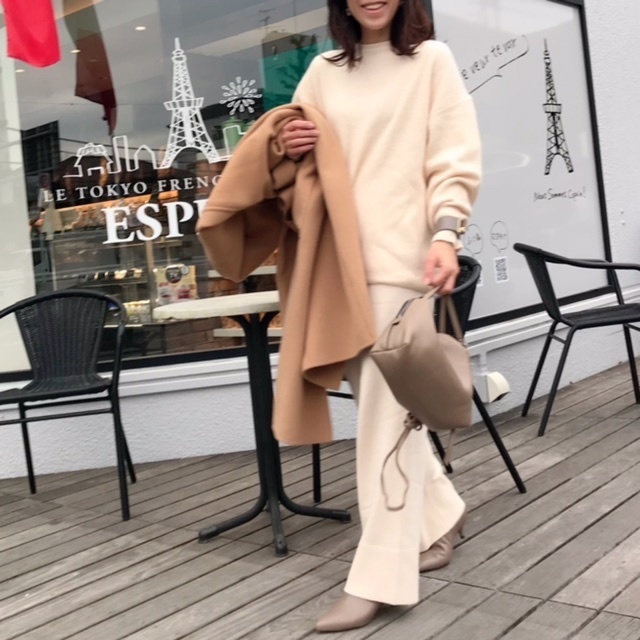 白ニットセットアップとキャメルコートのコーディネート