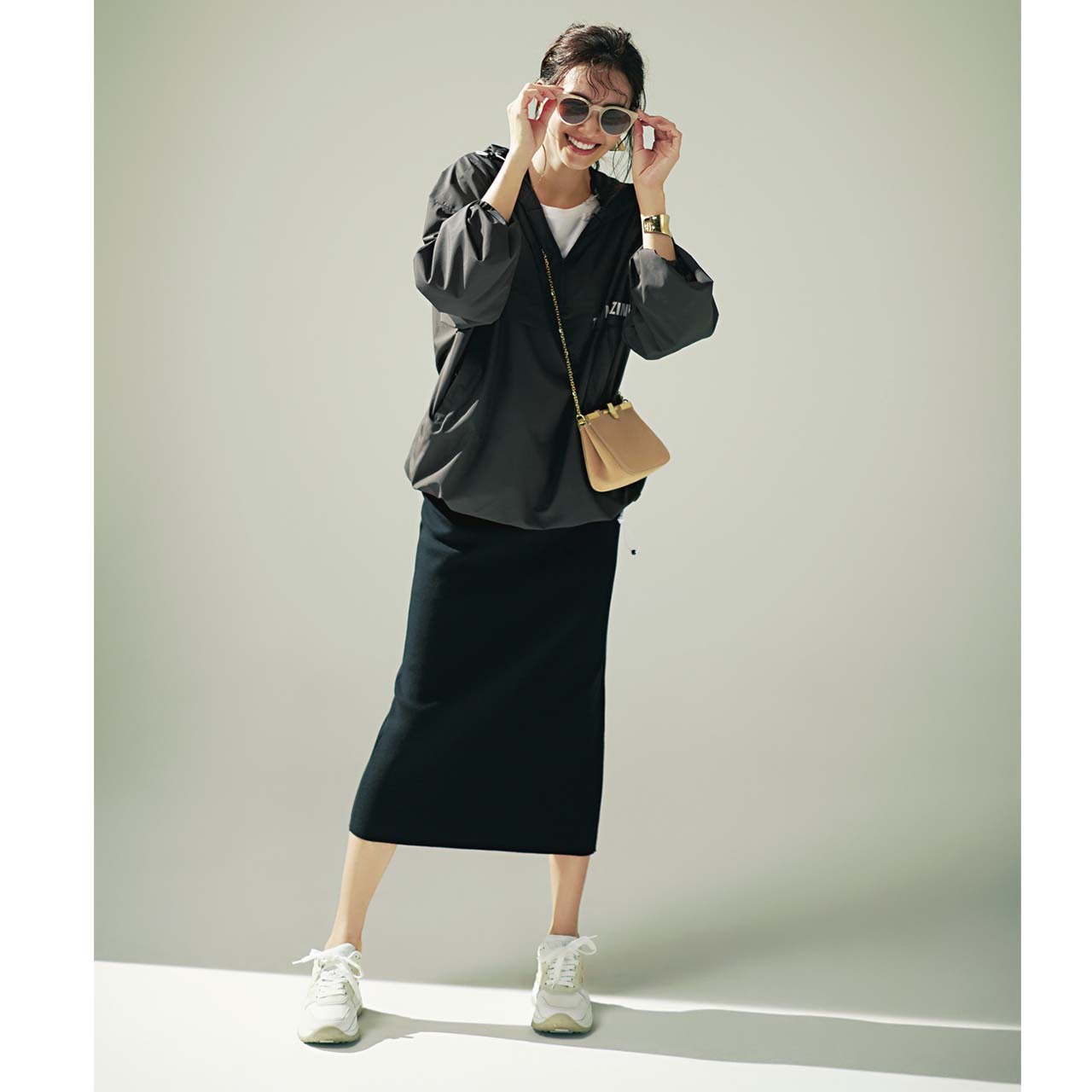 黒ブルゾン×白スニーカー×ベージュバッグコーデを着たモデルのRINAさん