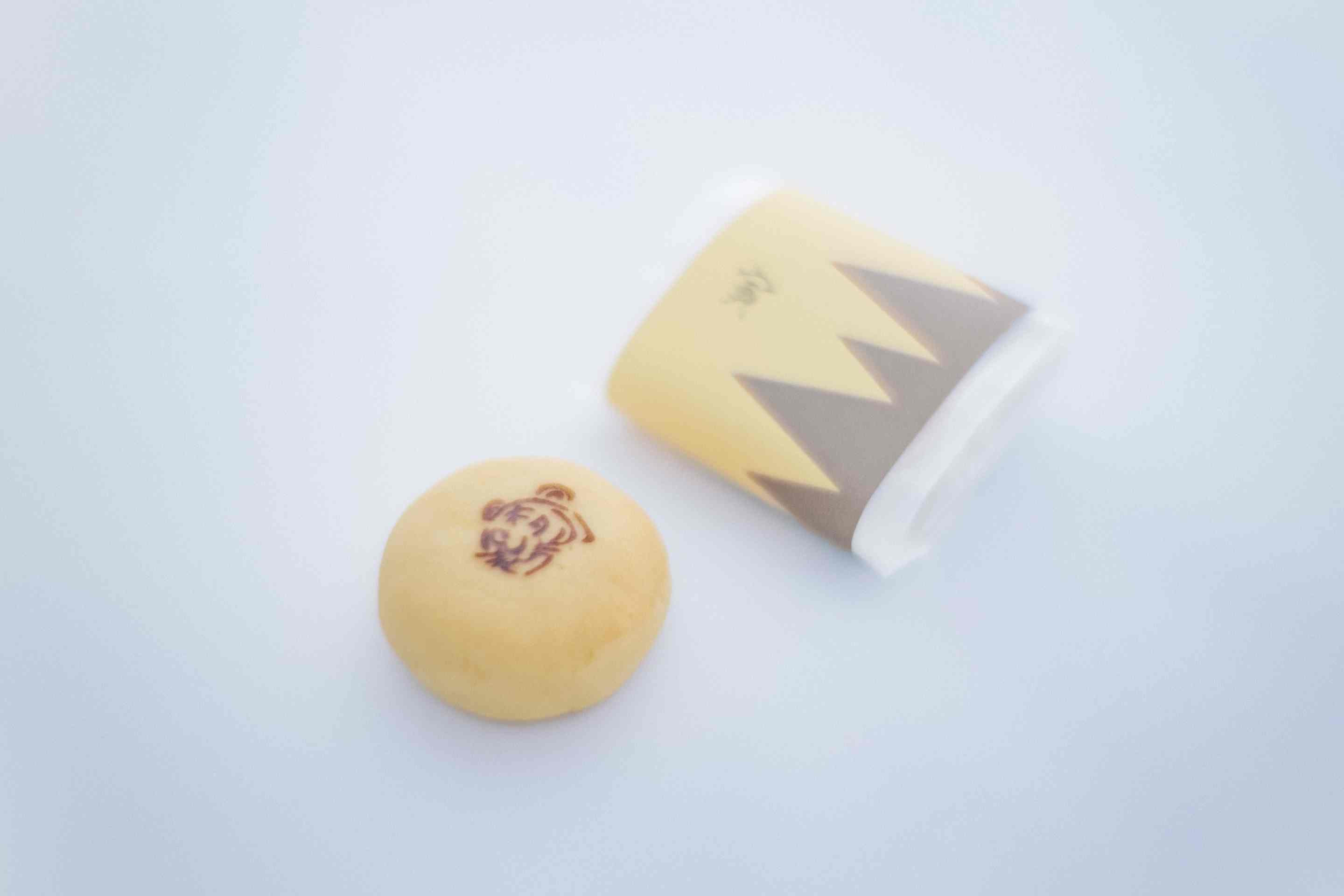 ギザギザの包みと小さな焼き印がかわいい。中は白餡。干支桃山「寅」1個173円。日持ちは約20日。