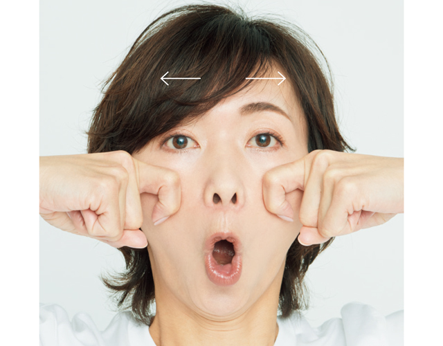 カギ形に曲げた人さし指を頰骨の内側に