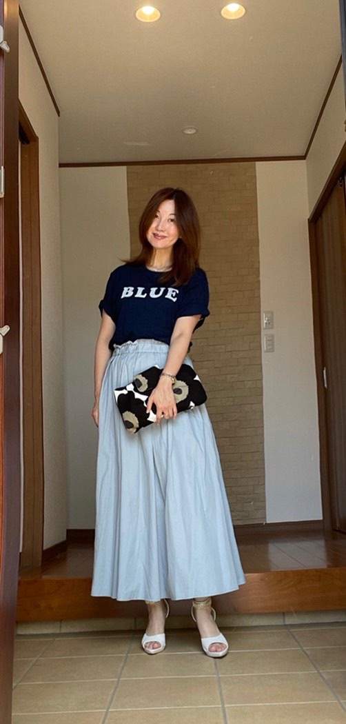 玄関女性 インディゴのTシャツに淡いブルーのマキシスカート